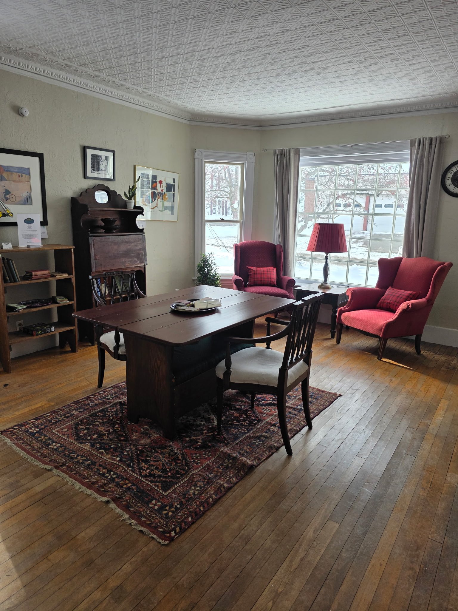 Main-house gathering room with artwork, antique furniture and decorative ceilings.
